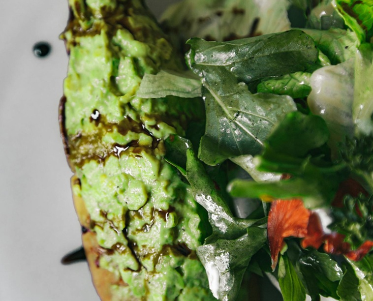 smashed avo on a bread sub, drizzled balsamic vinegar and mixed greens